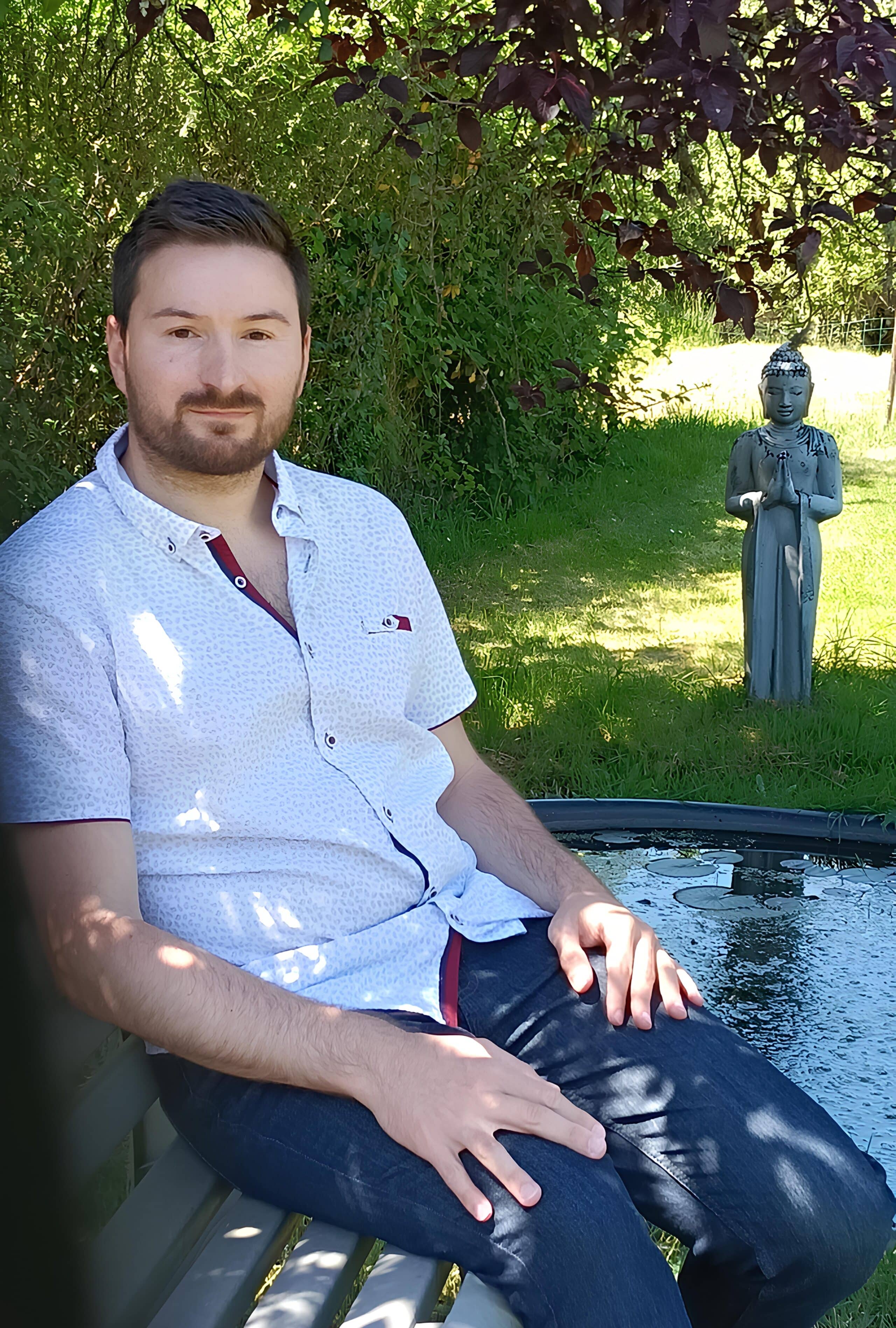 Homme assis près d'une statue extérieure